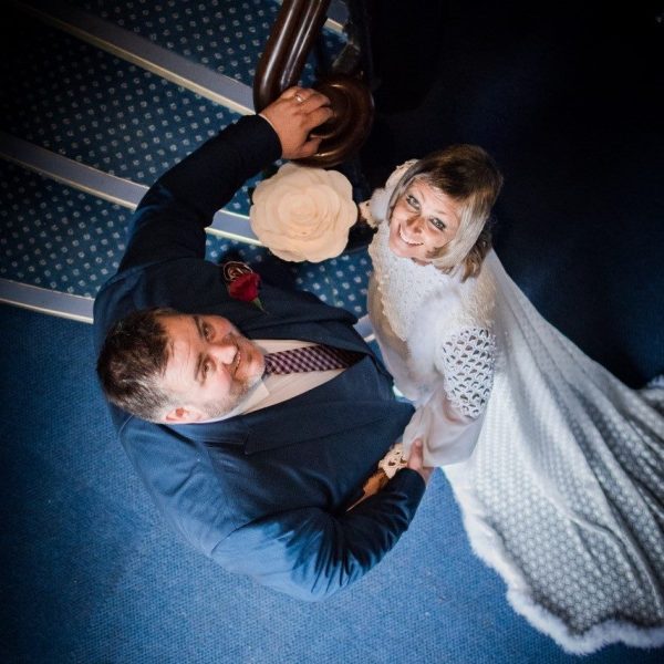 Photo of wedding couple at bottom of spiral stairs