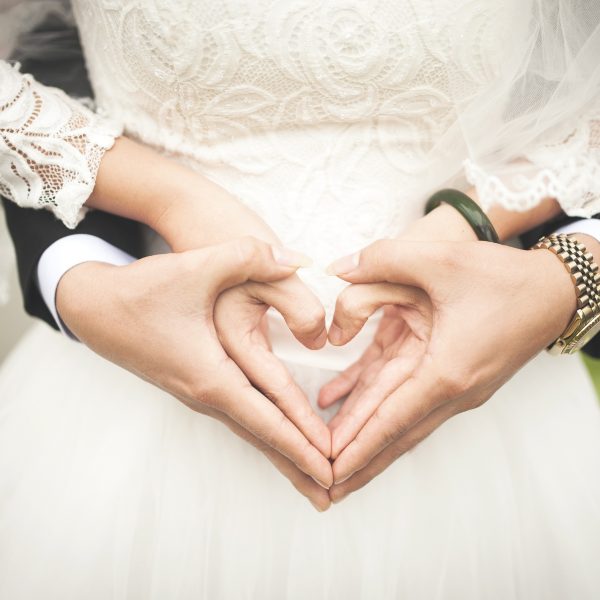 Wedding couple making hearts with hands photo